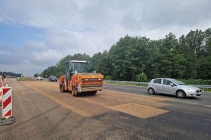 Układanie warstwy ścieralnej na przejeździe awaryjnym w Troszynie.jpg
